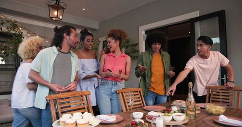 Friends Preparing Table for Dinner Party at Home Celebration