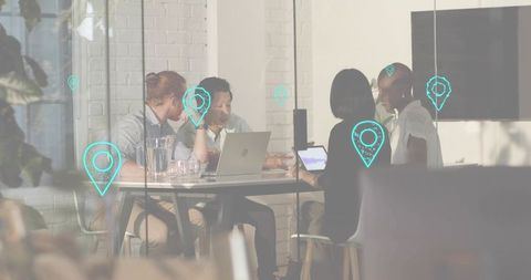 Team discussing project in glass-walled conference room with digital location pin overlay