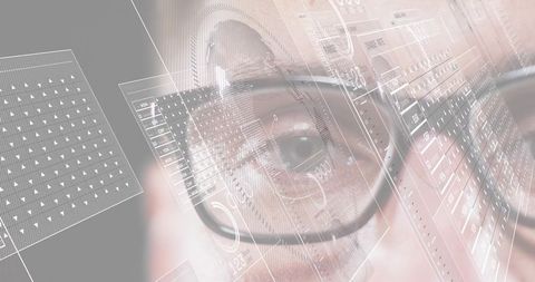 Mid-adult male wearing round eyeglasses analyzing HUD data with augmented reality overlays