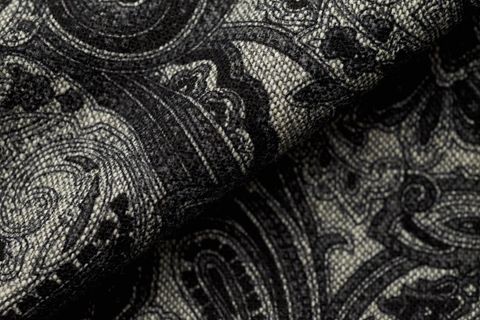 Folded black paisley wool fabric texture with woven detail for upholstery and fashion decor