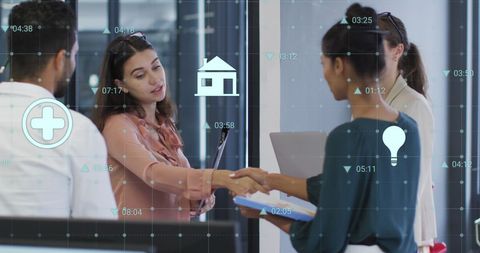 Diverse team shakes hands amidst business digital interface