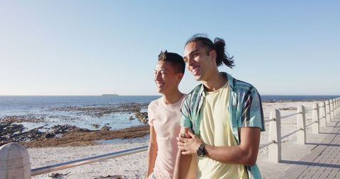 Happy Gay Couple Strolling by Seaside on Sunny Day