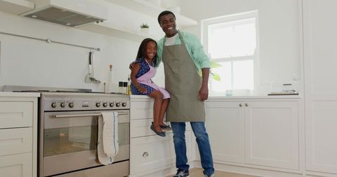 African American Father and Daughter Cooking in Modern Kitchen