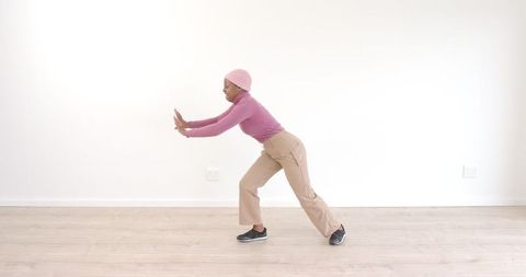 African american woman practicing balance exercise indoors