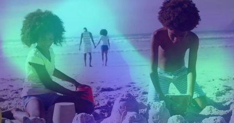 Children building sandcastles on beach with walking parents