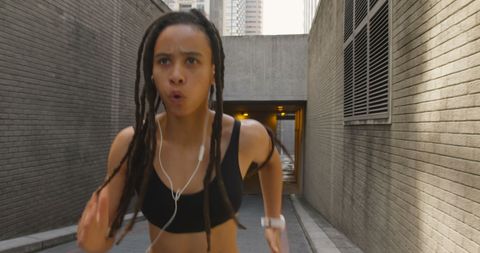Determined woman jogging through urban cityscape