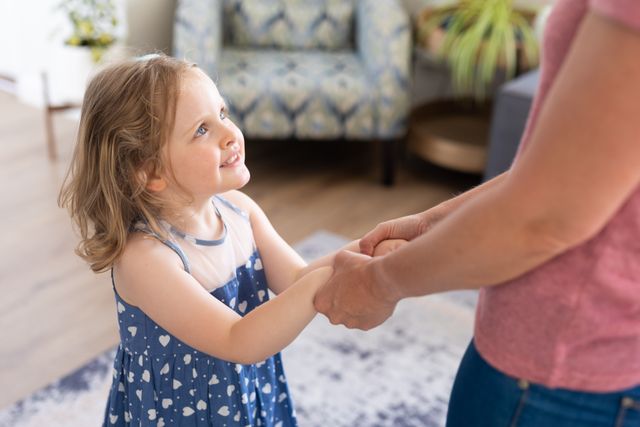 Caucasian Girl Holding Hands with Mother in Living Room - Download Free Stock Photos Pikwizard.com