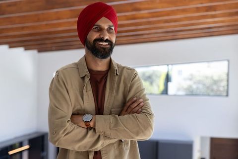 Confident indian man with arms crossed in modern interior