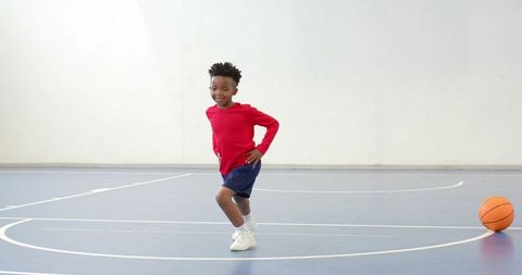 Energetic Boy Playing on Indoor Basketball Court