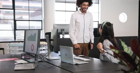 Cheerful business colleagues celebrating success in modern office