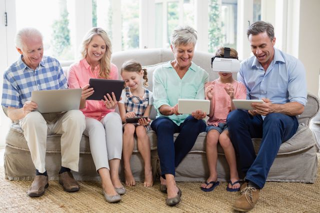 Multi-generation family using digital tablet, mobile phone and virtual headset in living room at home