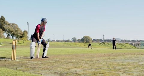 Cricketers Engaged in a Intense Match on Lush Green Field