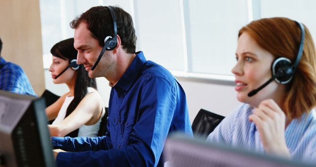 Caucasian middle-aged male and young female customer service representatives are wearing headsets and working in a call center, with copy space. They are focused on assisting clients, highlighting the importance of customer support in business operations.