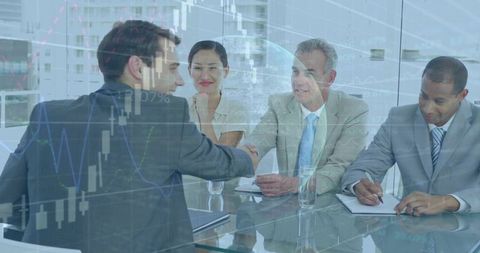 Executives Shaking Hands Across Glass Conference Table with Stock Market Chart Overlay