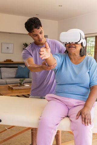 Senior Woman Using VR Headset for Rehabilitation at Home with Therapist