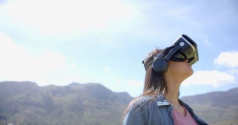 Woman exploring virtual reality with vr headset outdoors