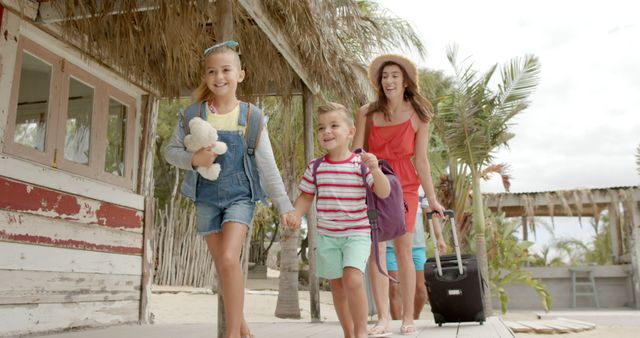 Happy caucasian family running with luggage at beach house. Vacation, free time, summer and family.