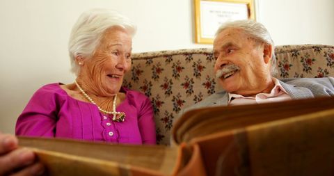 Seniors Joyfully Reminiscing with Old Photo Album - Download Free Stock Images Pikwizard.com