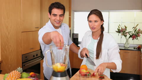 Couple Preparing Fresh Smoothie Together in Modern Kitchen