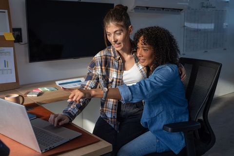 Diverse Coworkers Collaborating on Office Laptop