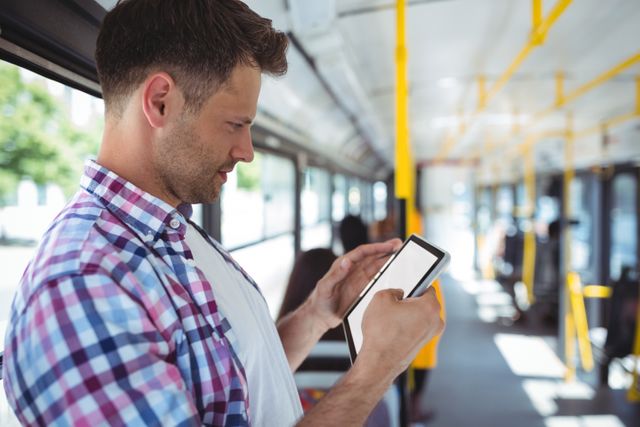 Handsome man using digital tablet in bus