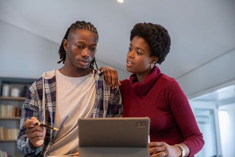 African American Couple Collaborating on Tablet in Loft Office