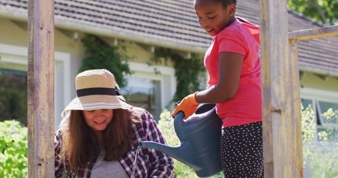 Mother and Daughter Joyfully Gardening Together Home