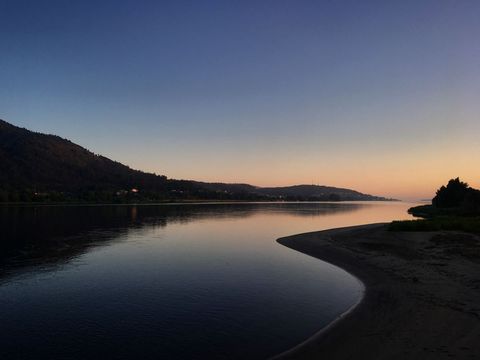 Serene River at Dusk Amidst Gently Sloping Hills