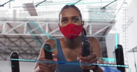 High-intensity indoor cycling woman wearing mask pedaling with fitness hud overlay