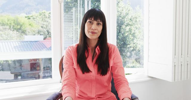 Confident Woman Sitting in Bright Office with Mountain View - Download Free Stock Images Pikwizard.com