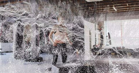 Female Athlete Standing in Industrial Gym Surrounded by Mist Curtain During Training