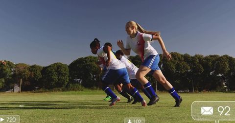 Female soccer team sprinting together in unity on sunny field