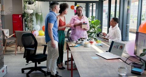 Businesswoman celebrating with colleagues at office party gathering