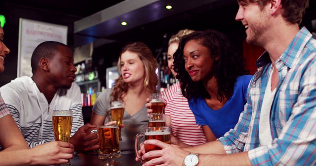 Group of friends enjoying drinks at a lively bar, engaging in casual conversation and laughing. Perfect for use in advertisements for bars, nightlife promotions, social interaction themes, and illustrating friendship and diversity.