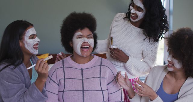 Happy diverse female friends doing make up and masks together. healthy and active time holiday.