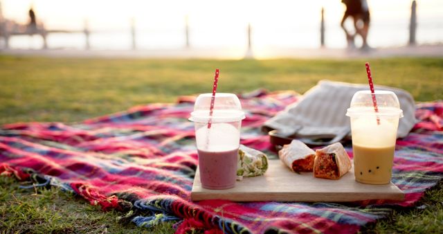 Food and drinks on on blanket by the sea at sunset. Summer, vacations, food and drink and picnic unaltered.