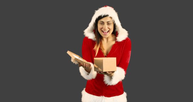 Woman Wearing Santa Claus Outfit Opening Christmas Gift with Excitement - Download Free Stock Images Pikwizard.com