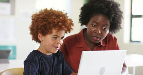 African American Mentor Guiding Young Student Using Laptop for Tutoring and Learning