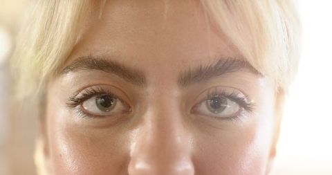 Woman with Green Eyes Under Warm Lighting, Dewy Skin Beauty Portrait