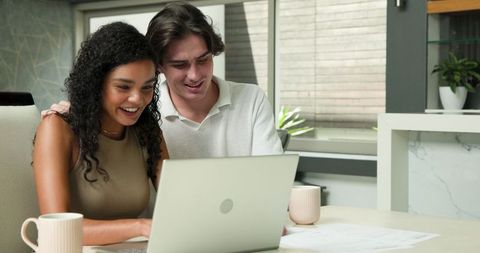 Happy Couple Using Laptop in Living Room for Lifestyle and Communication