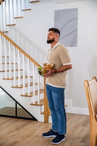 Man Holding Salad Bowl in Modern Minimalist Home Interior