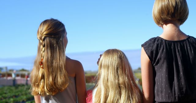 Three Young Girls Enjoying Scenic Outdoor View under Vibrant Sky - Download Free Stock Images Pikwizard.com