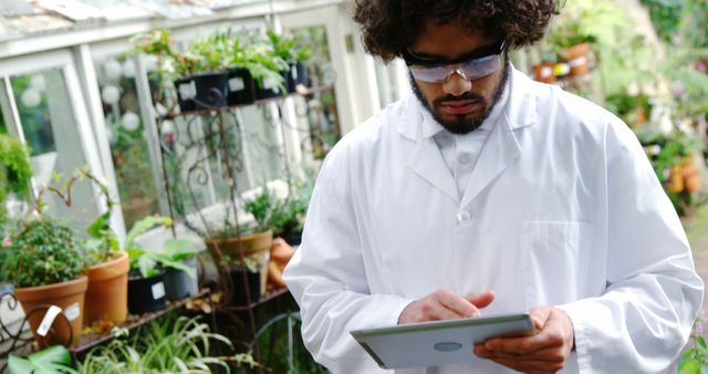 Botanist Using Tablet in Greenhouse Wearing Lab Coat - Download Free Stock Images Pikwizard.com