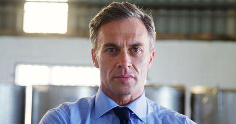 Confident businessman in blue shirt at modern workplace