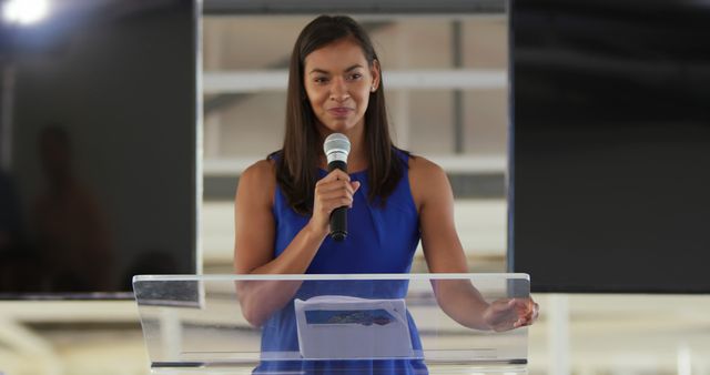 Confident Woman Speaking at a Podium with Microphone - Download Free Stock Images Pikwizard.com