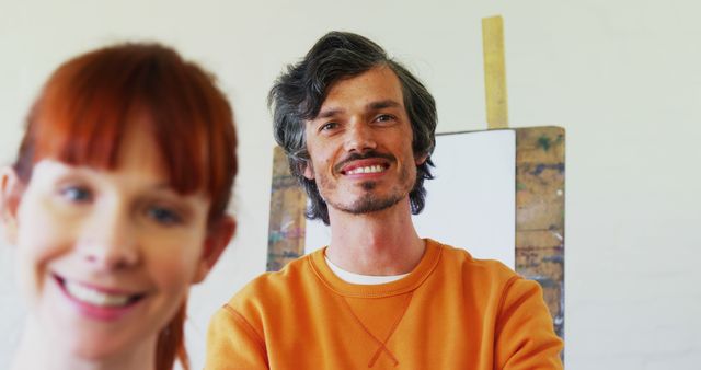Man Smiling in Art Studio with Woman in Foreground - Download Free Stock Images Pikwizard.com