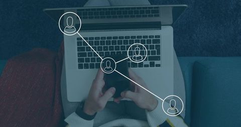 Holding phone and using laptop on couch with connected user overlay for remote work