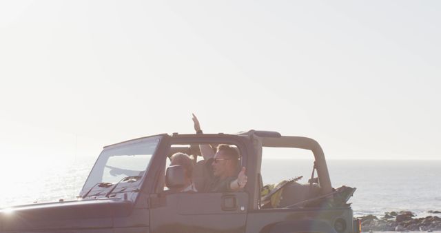 Couple in a convertible jeep driving along the coastal road on a sunny day, sharing fun and joyful moments. Ideal for concepts related to travel, adventure, road trips, freedom, and lifestyle. Useful for tourism promotions, vehicle advertisements, travel blogs, and social media posts celebrating outdoor adventures and couple's getaways.