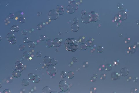 Floating Soap Bubbles Against Clear Blue Sky