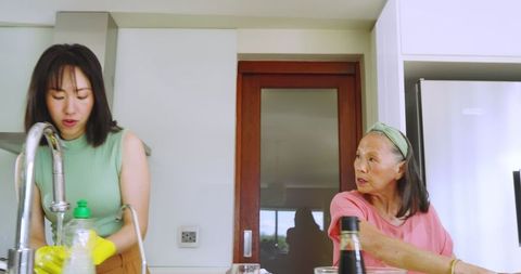 Asian Mother and Daughter Engaging in Kitchen Chores Cheerfully